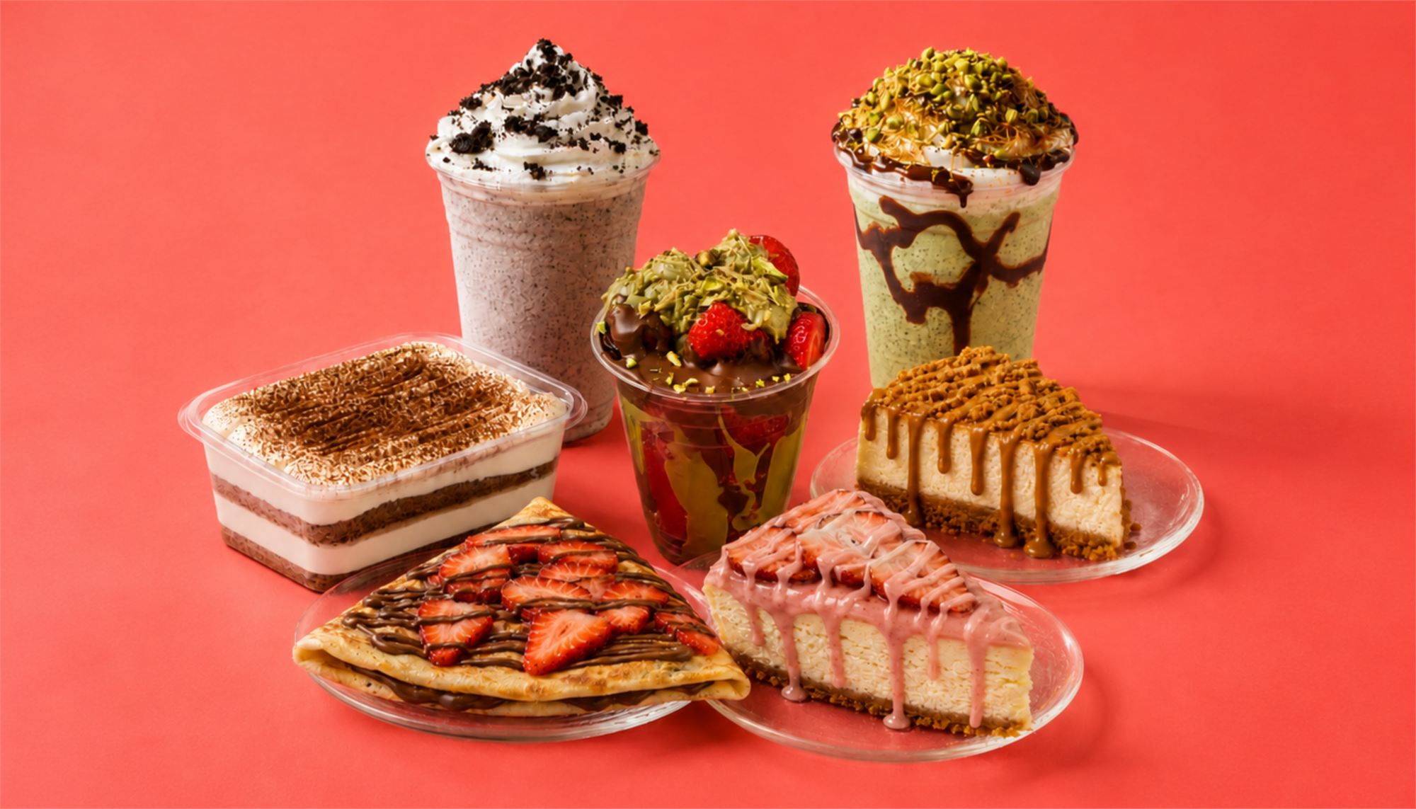 A spread of Plate of Cake desserts — cheesecakes, crepes and milkshakes on the counter