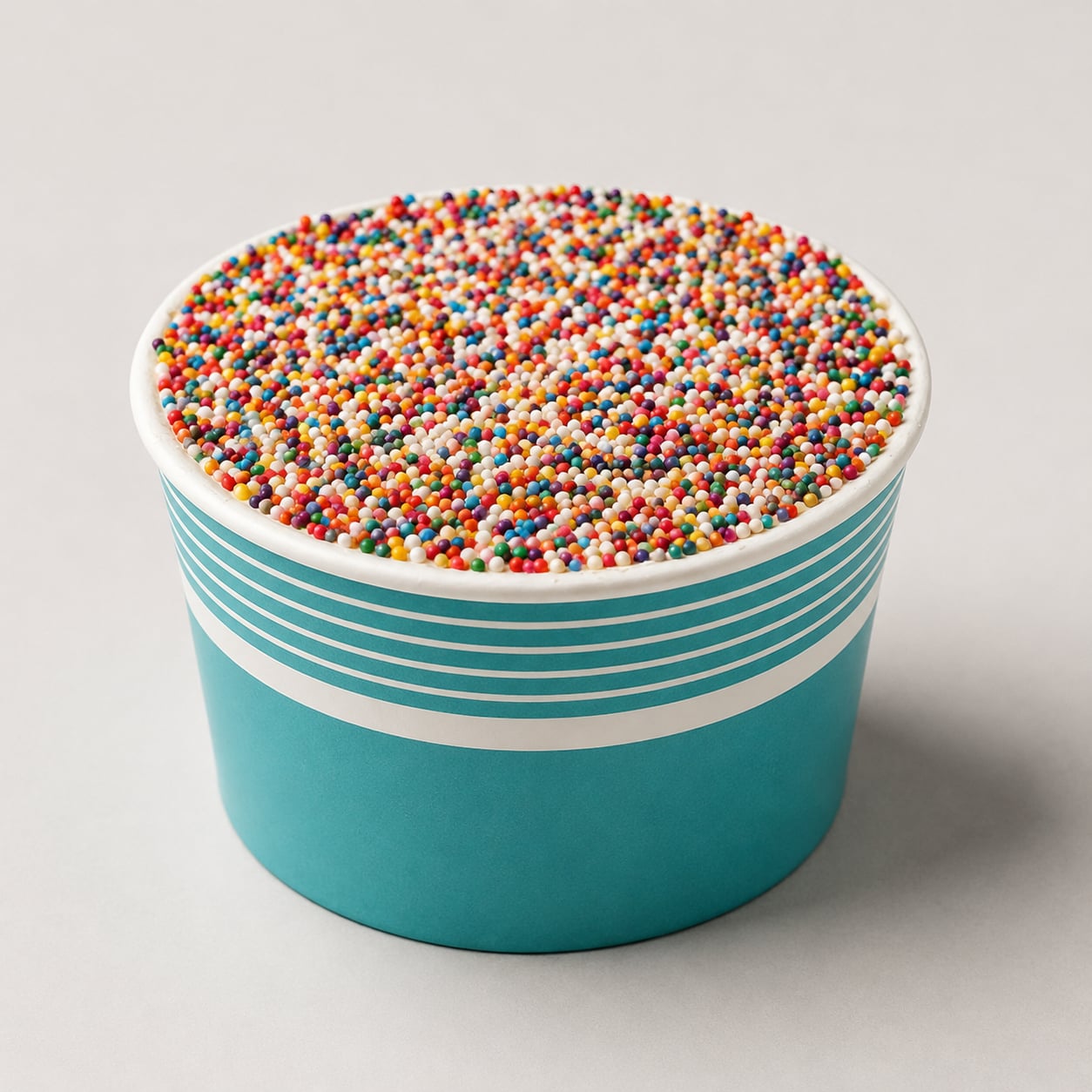 A single Sprinkle Cake — a teal-and-white striped cup topped with a dome of rainbow nonpareil sprinkles